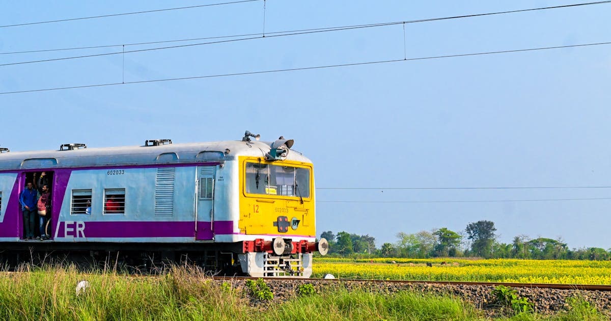 Train on scenic Konkan railway surrounded by lush greenery